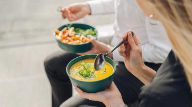 Zwei Personen löffeln Suppe aus einer Mehrwegschale