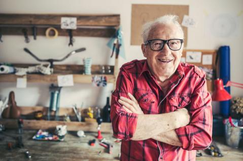 Alter Mann mit Brille in seiner Werkstatt