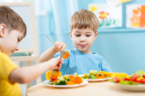 Kinder beim Essen im Kindergarten
