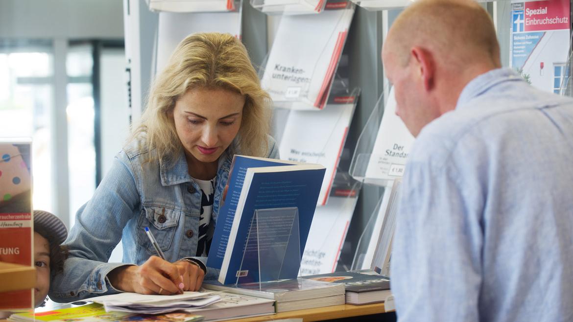 Verbraucherin mit Kind im Infozentrum der Verbraucherzentrale Hamburg
