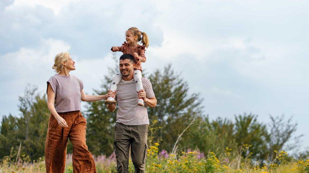 Familie mit Kind geht über Wiese