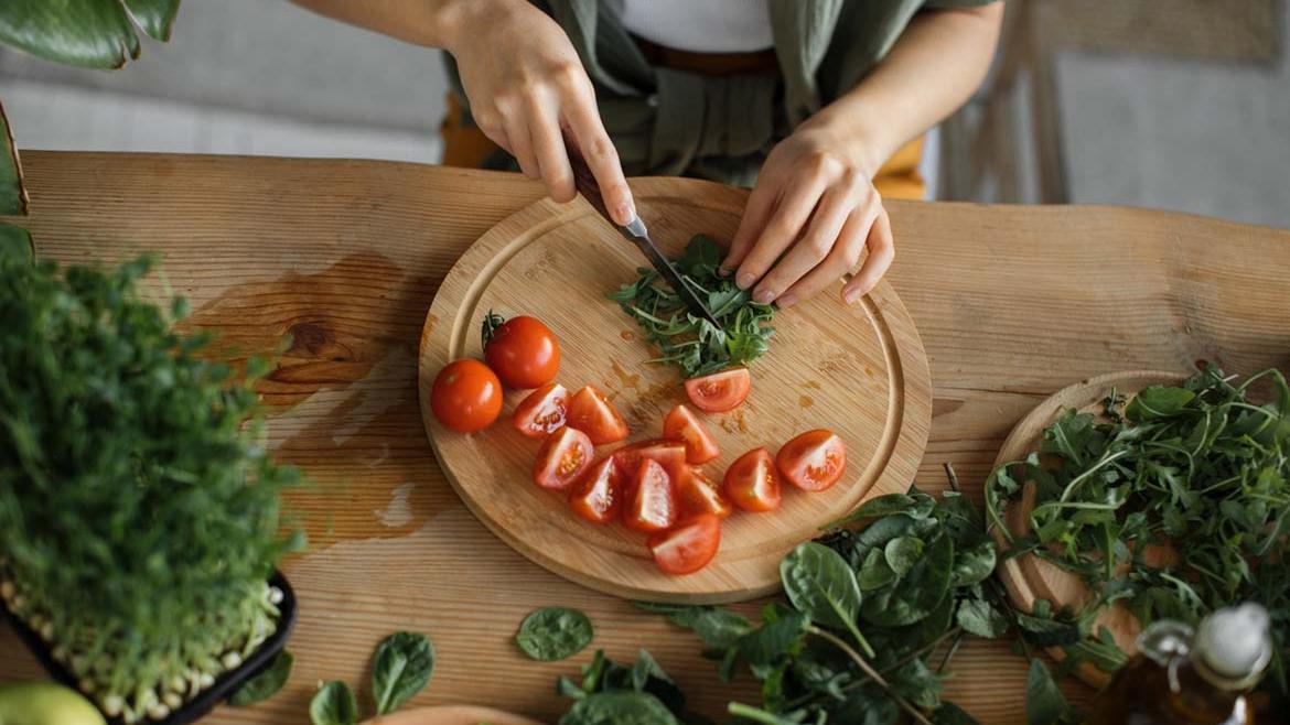 Frau schneidet Rucola