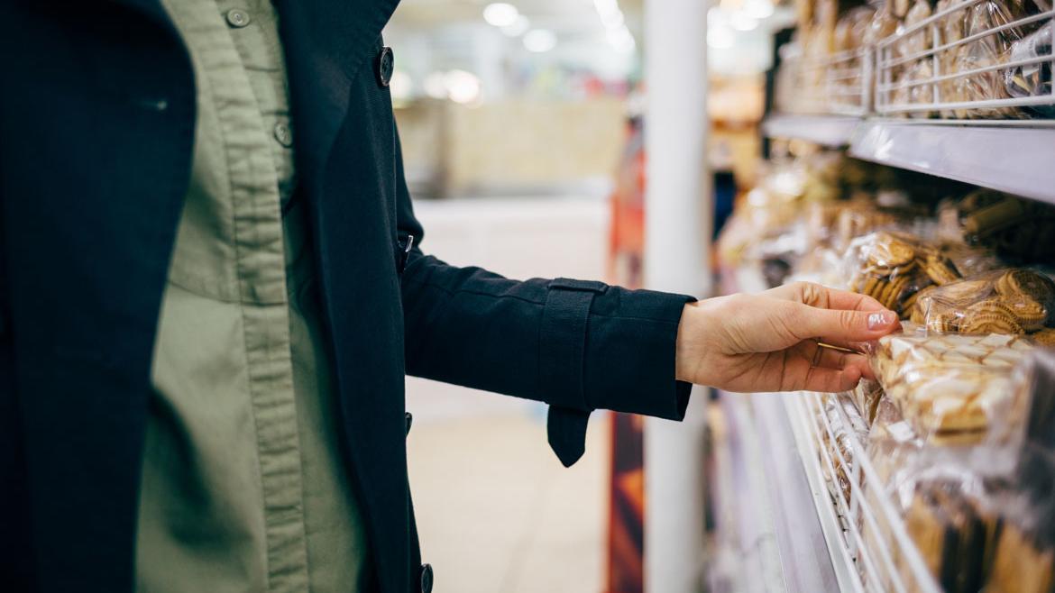 Frau wählt Kekse im Supermarktregal aus