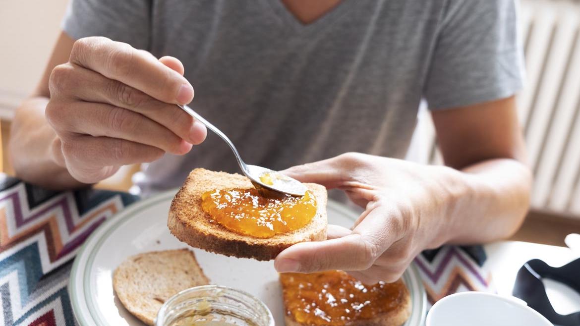 Mann isst Toast mit Marmelade