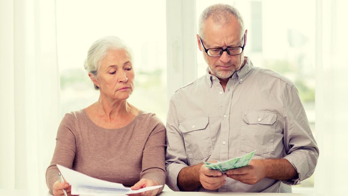Älteres Ehepaar schaut auf Geldscheine