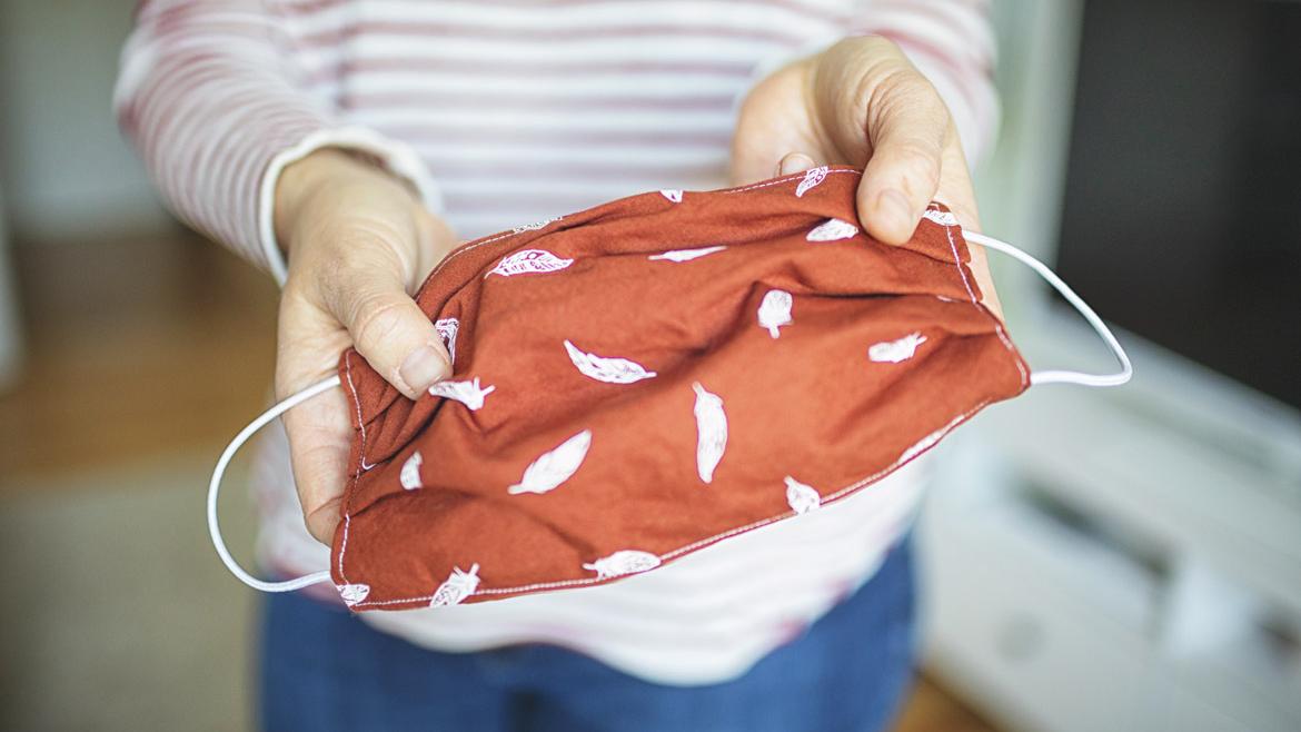 Selbst genähte Schutzmaske in der Hand