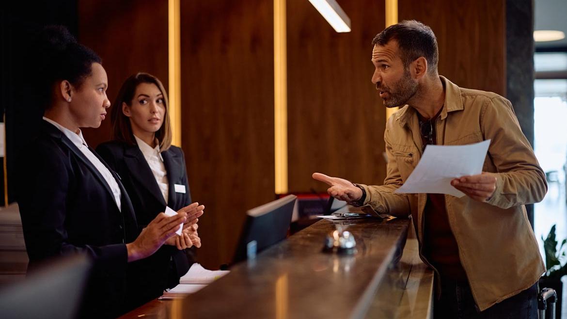 Unzufriedener Hotelgast an Rezeption
