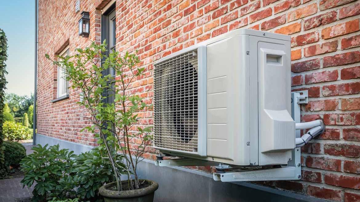 Wärmepumpe an einer Hausfassade mit Klinkersteinen