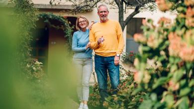 Ehepaar im Garten mit Schlüssel in der Hand