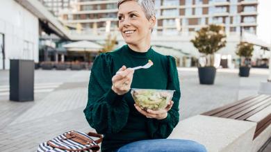 Frau macht Mittagspause mit Essen