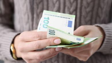 Frau mit 100-Euro-Scheinen in der Hand