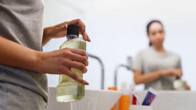 Frau mit Flasche Mundspülung in der Hand