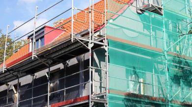 Haus mit frischer Dämmung und Gerüst an der Fassade