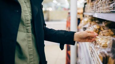 Frau wählt Kekse im Supermarktregal aus