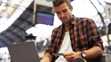 Mann mit Laptop und Kreditkarte