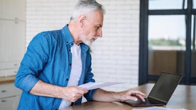 Mann schaut kritisch auf einen Laptop