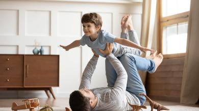 Vater spielt mit Sohn auf Fußboden