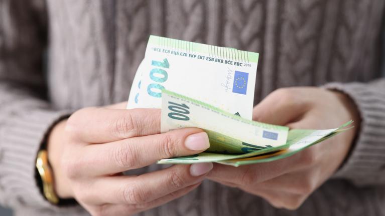 Frau mit 100-Euro-Scheinen in der Hand