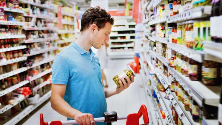 Mann mit Glas im Supermarkt