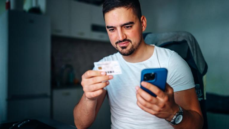 Mann mit Smartphone und Karte in der Hand