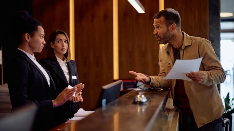 Unzufriedener Hotelgast an Rezeption