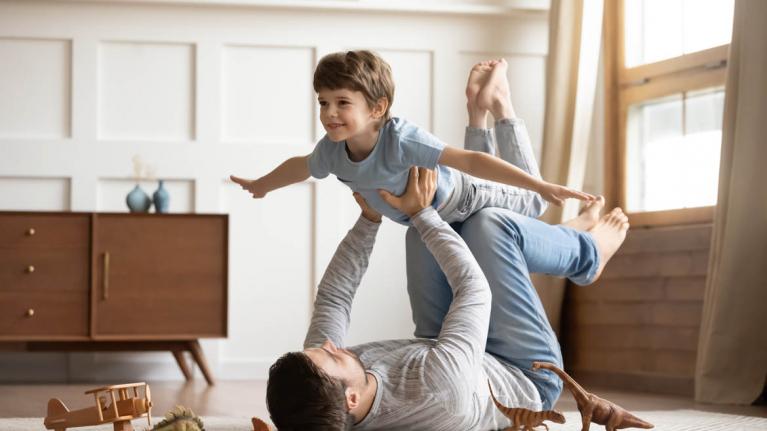 Vater spielt mit Sohn auf Fußboden