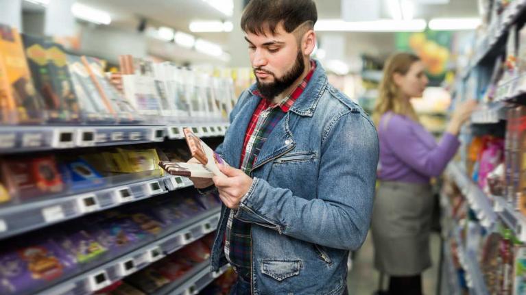 Verbraucher am Schokoladenregal im Supermarkt