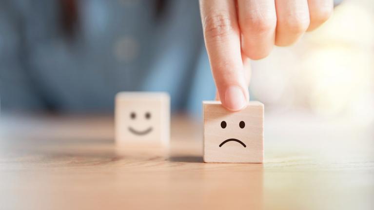 Hand dreht Würfel mit Smileys