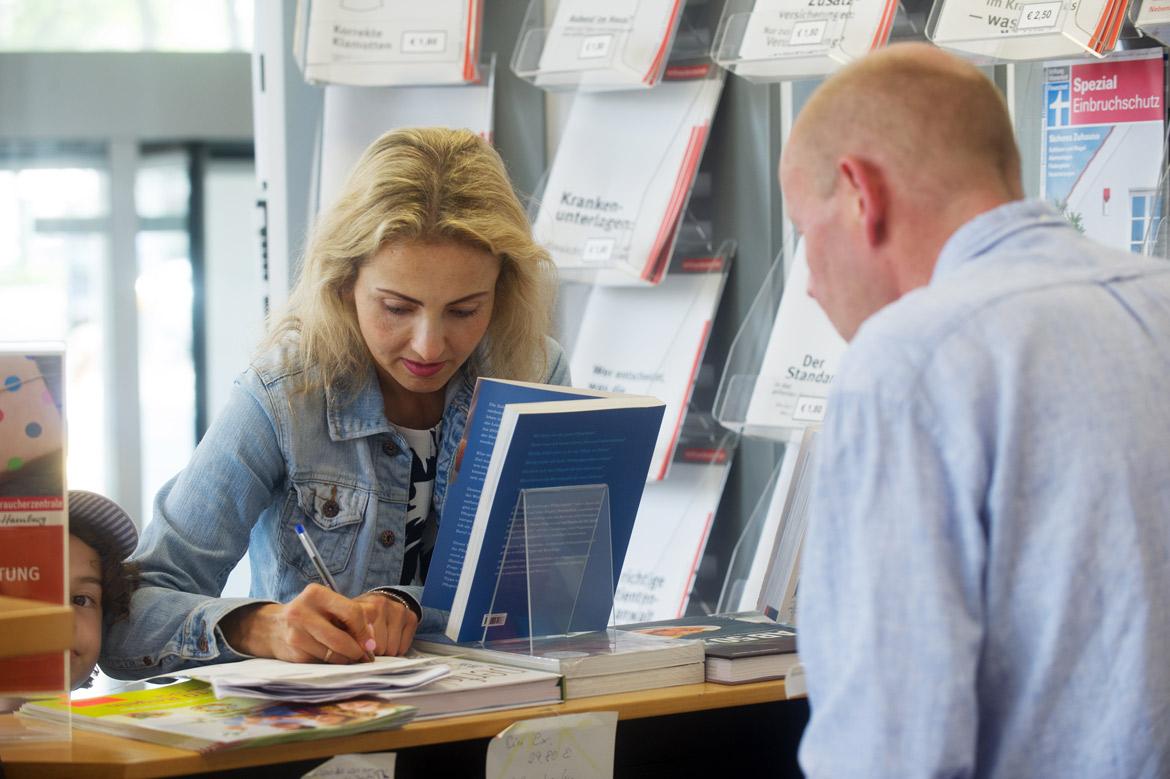 Verbraucherin mit Kind im Infozentrum der Verbraucherzentrale Hamburg