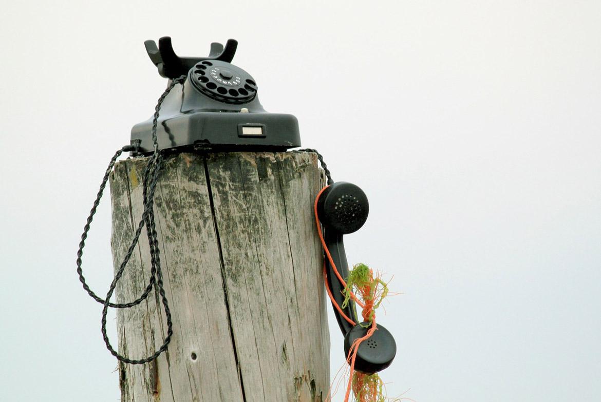 Altes Telefon auf Holzmast