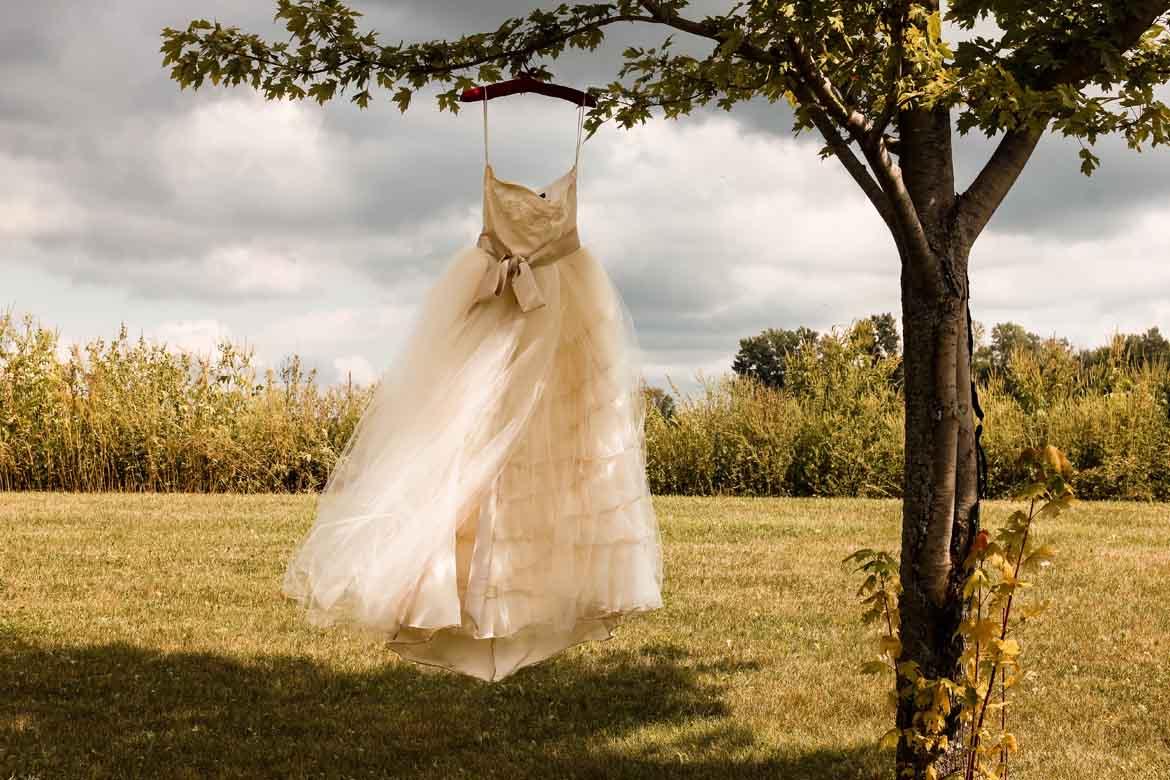 Ein Brautkleid, das mit einem Kleiderbügel an einem Baum hängt