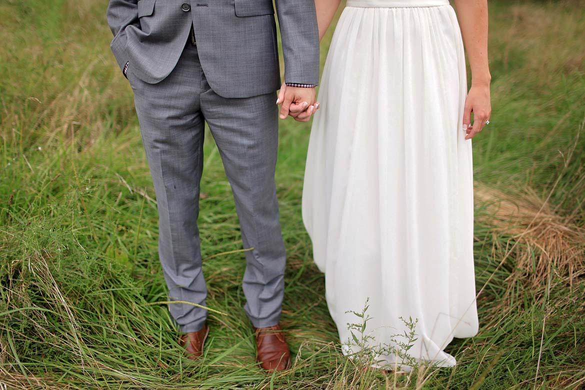 Beine eines Brautpaares auf Wiese