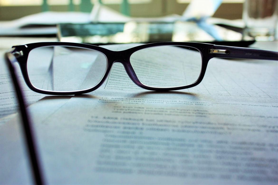 Brille liegt auf Dokument