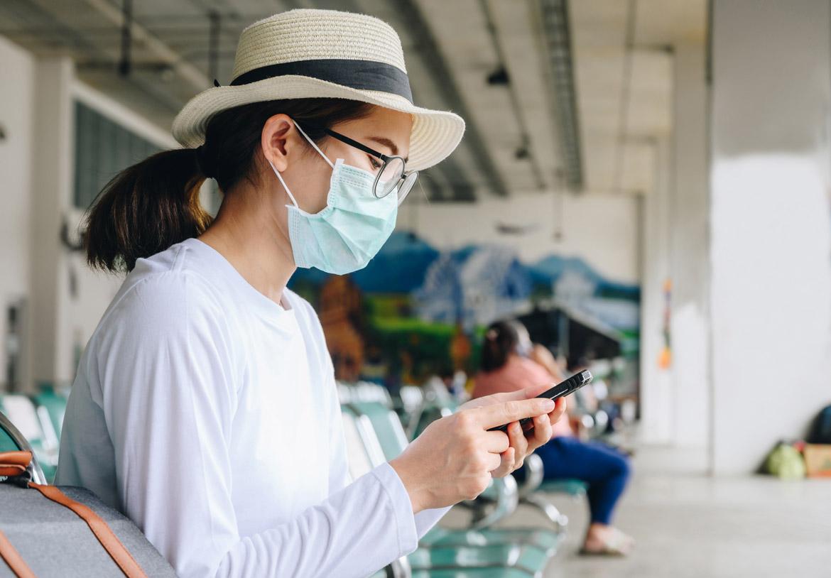 Frau mit Maske am Flughafen