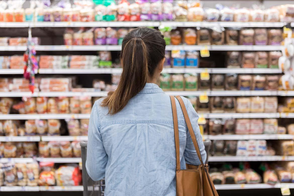 Frau vor Supermarktregal mit Brot