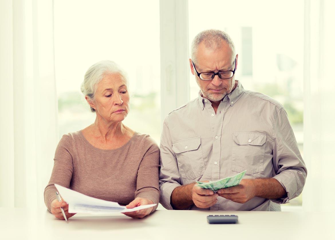 Älteres Ehepaar schaut auf Geldscheine