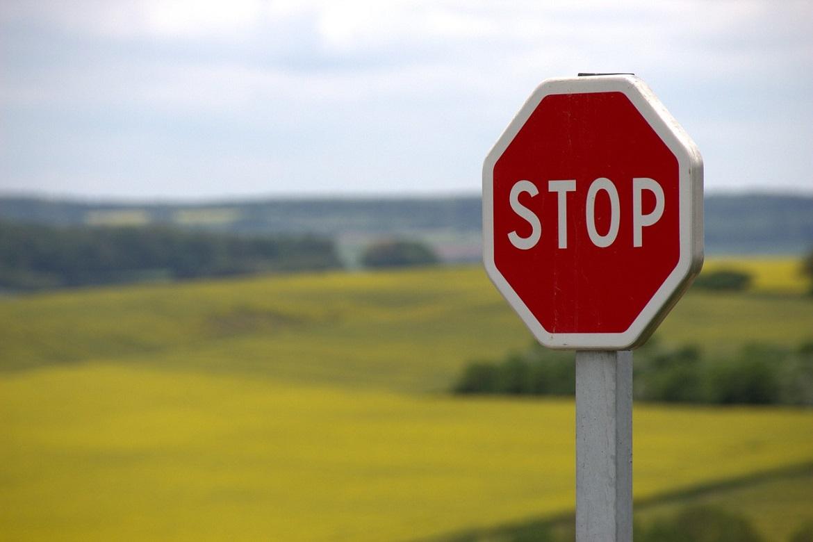 Stopp-Schild mit Landschaft im Hintergrund