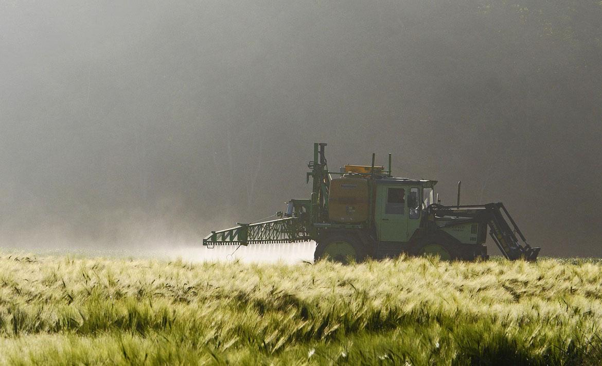 Traktor mit Spritze auf dem Feld