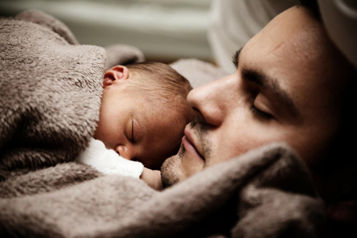 Mann mit schlafendem Baby
