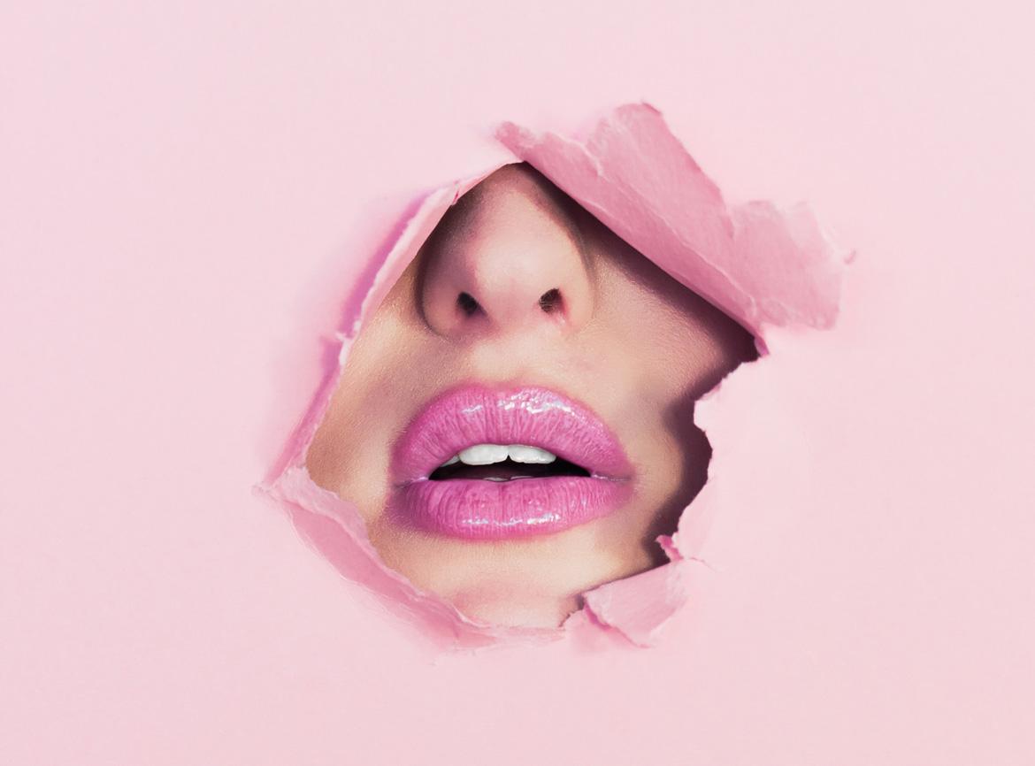 Gesicht mit rosafarbenen Lippen hinter rosafarbener Wand