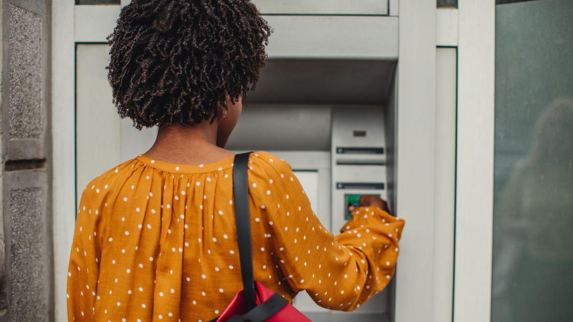 Frau zieht Geld am Automaten
