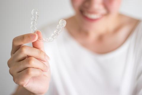 Frau mit Aligner in der Hand