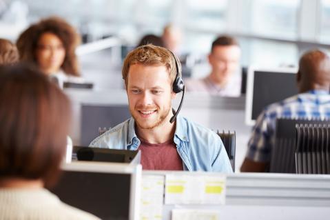 Junger Mann mit Headset im Callcenter