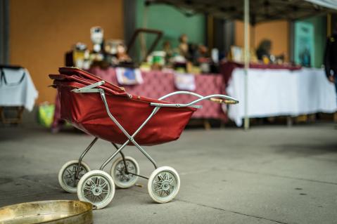 Roter Puppenwagen auf Flohmarkt