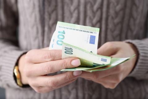 Frau mit 100-Euro-Scheinen in der Hand