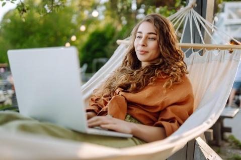 Frau mit Laptop in Hängematte