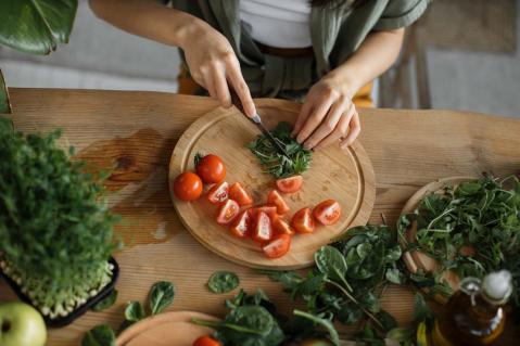 Frau schneidet Rucola