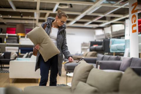 Frau schaut sich ein Sofa in einem Möbelhaus an