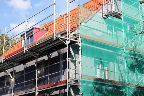 Haus mit frischer Dämmung und Gerüst an der Fassade