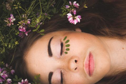 Junge Frau mit Blumen im Gras